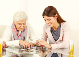 caregiver playing puzzle with senior woman
