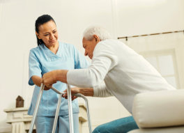 caregiver helping senior man stand-up