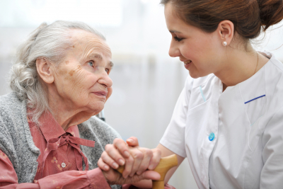 caregiver holding hands with senior woman